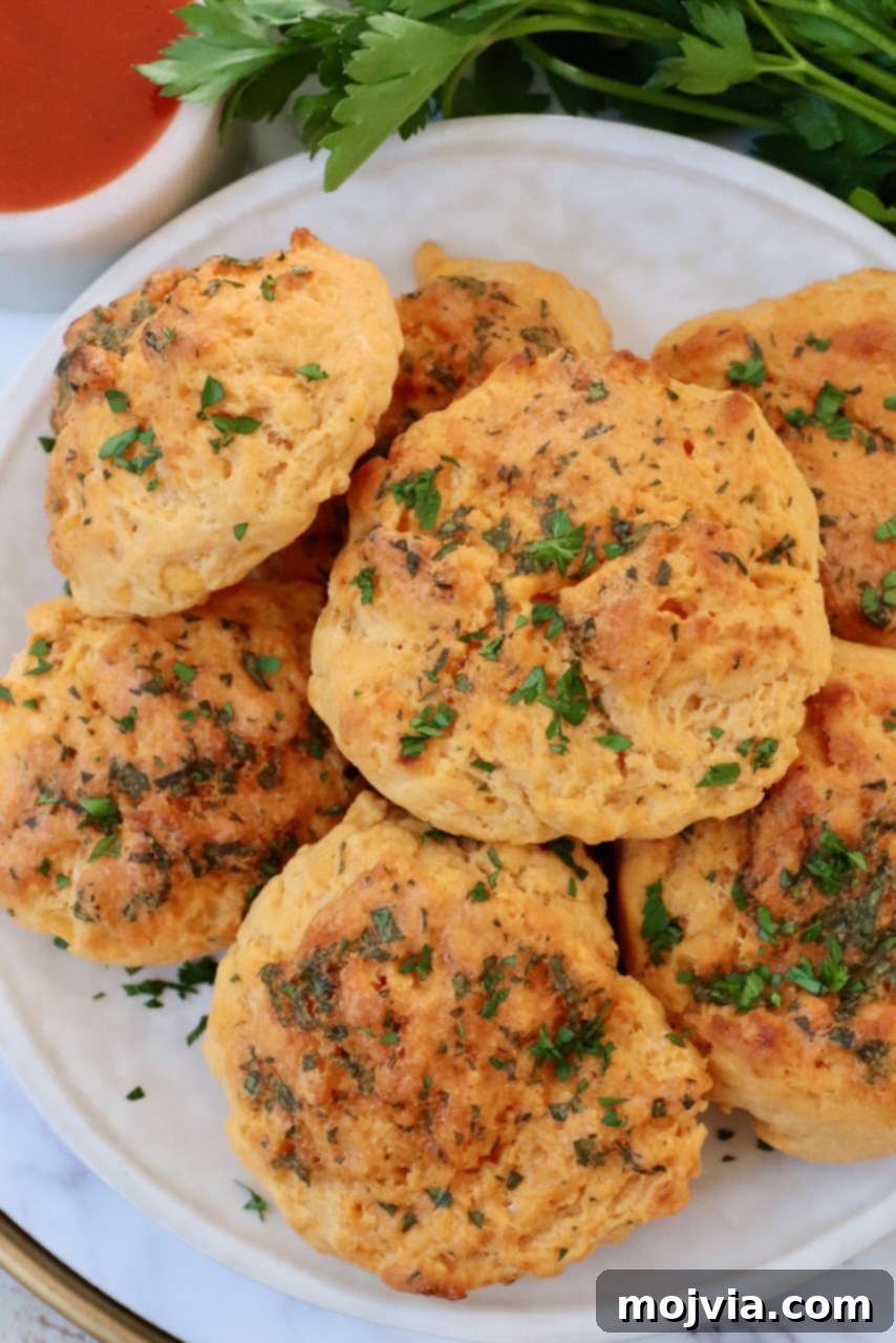 Buffalo Cheddar Zingers 6 cheddar biscuits stacked up on a plate with fresh parsley