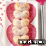 Strawberry cheesecake filling is wrapped up in heart shaped puff pastry dough in this mini strawberry cheesecake pie recipe, perfect for Valentine's Day!