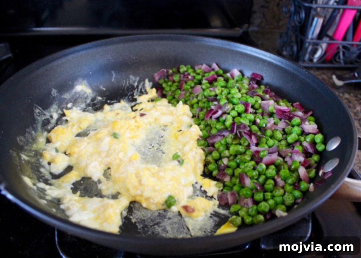 Spicy Sriracha Steak Fried Rice 4 Combining eggs and vegetables in a pan for Sriracha Steak Fried Rice