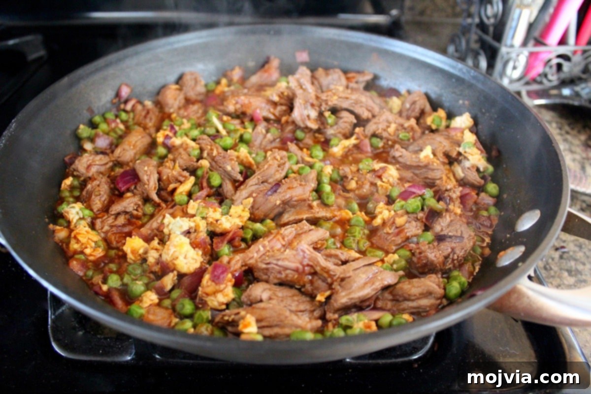 Spicy Sriracha Steak Fried Rice 5 Adding soy sauce, ginger, and Sriracha to the steak and vegetable mixture