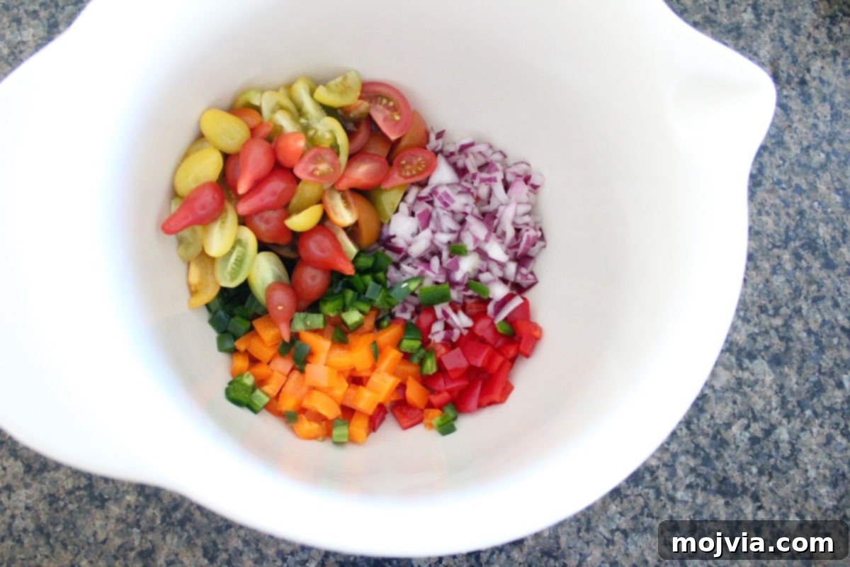 Creamy Avocado Pearl Couscous Salad 4 Diced bell peppers, red onion, jalapeno, and cherry tomatoes in a large mixing bowl