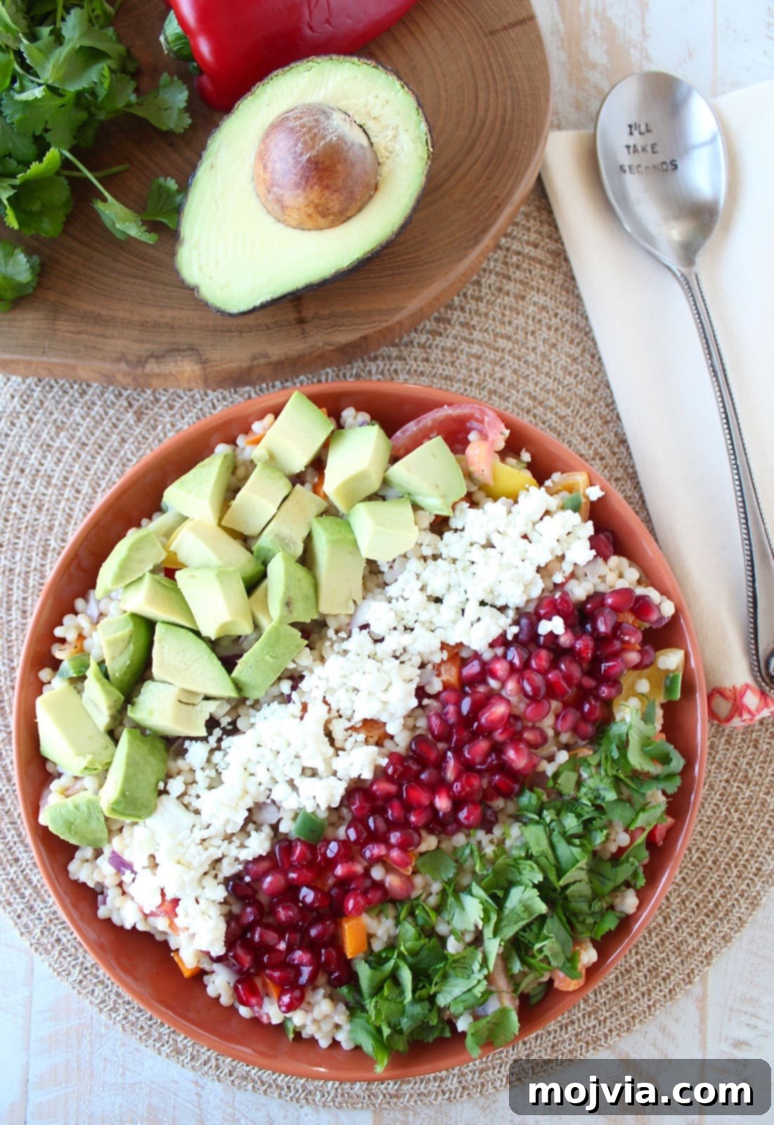 Creamy Avocado Pearl Couscous Salad 5 Beautifully assembled Israeli couscous avocado salad in an orange serving bowl