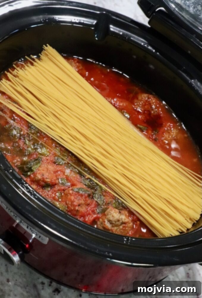 Set-and-Forget Slow Cooker Meatballs and Marinara 11 uncooked spaghetti noodles in slow cooker with Italian meatballs and marinara sauce