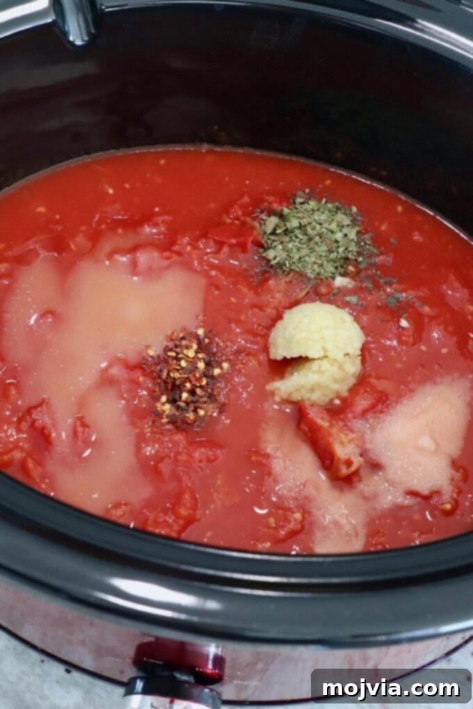 Set-and-Forget Slow Cooker Meatballs and Marinara 5 tomato sauce in slow cooker topped with spices and herbs