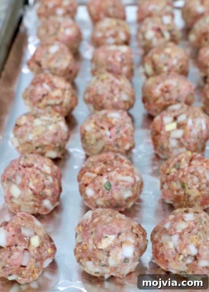 Set-and-Forget Slow Cooker Meatballs and Marinara 7 uncooked meatballs on foil lined baking sheet