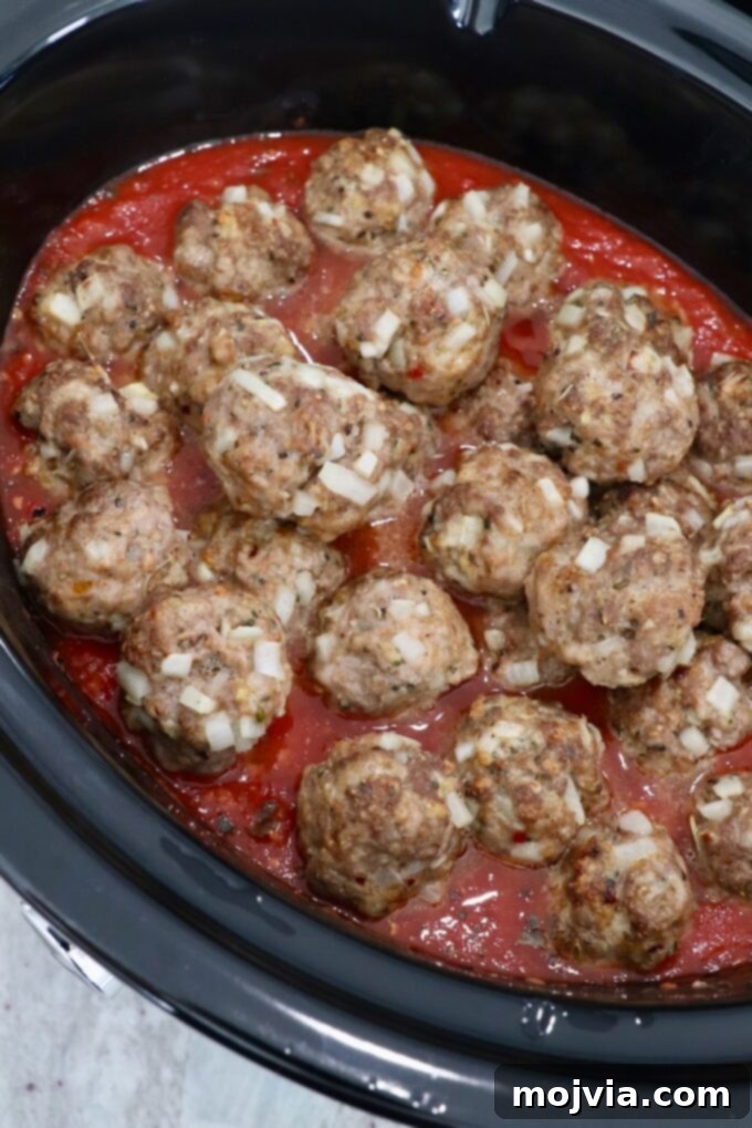 Set-and-Forget Slow Cooker Meatballs and Marinara 8 cooked meatballs in slow cooker with tomato sauce