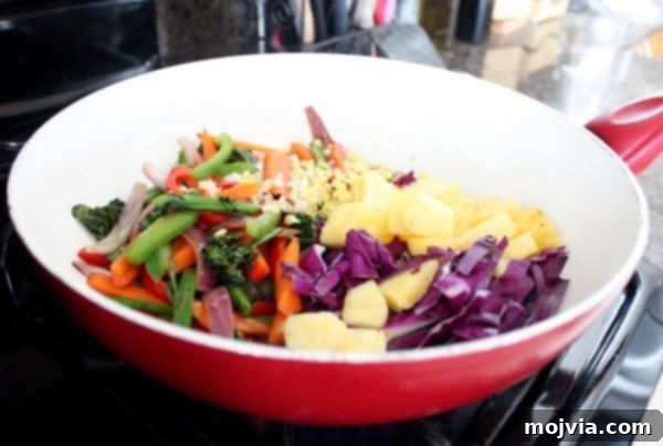 Vibrant Thai Peanut Pineapple Bowl 8 Adding garlic, ginger, red cabbage, and pineapple to sautéed vegetables