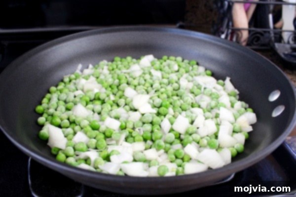 Sautéing onions and peas for Green Curry Chicken Fried Rice