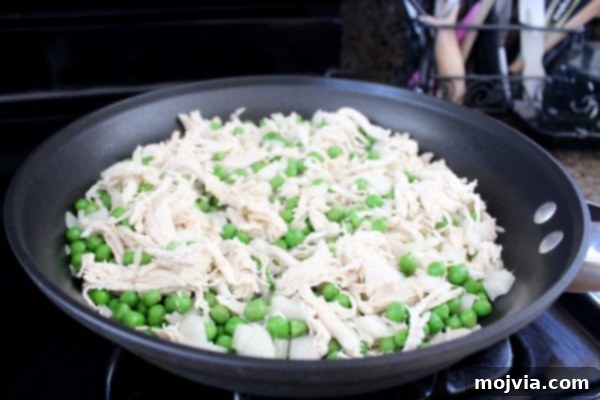 Adding chicken to the fried rice mixture