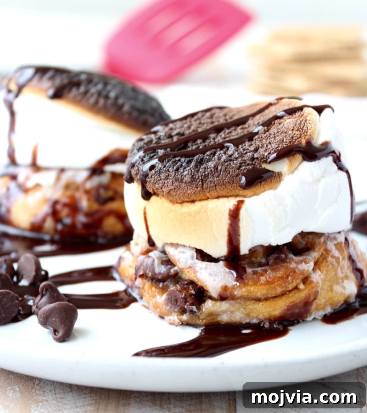 S'Mores Cinnamon Rolls stacked on a plate, showing the gooey filling and toasted marshmallow topping.