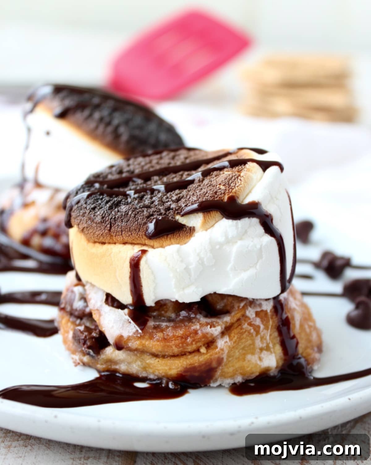 Close-up of S'Mores Cinnamon Rolls, showcasing the gooey chocolate and marshmallow topping.