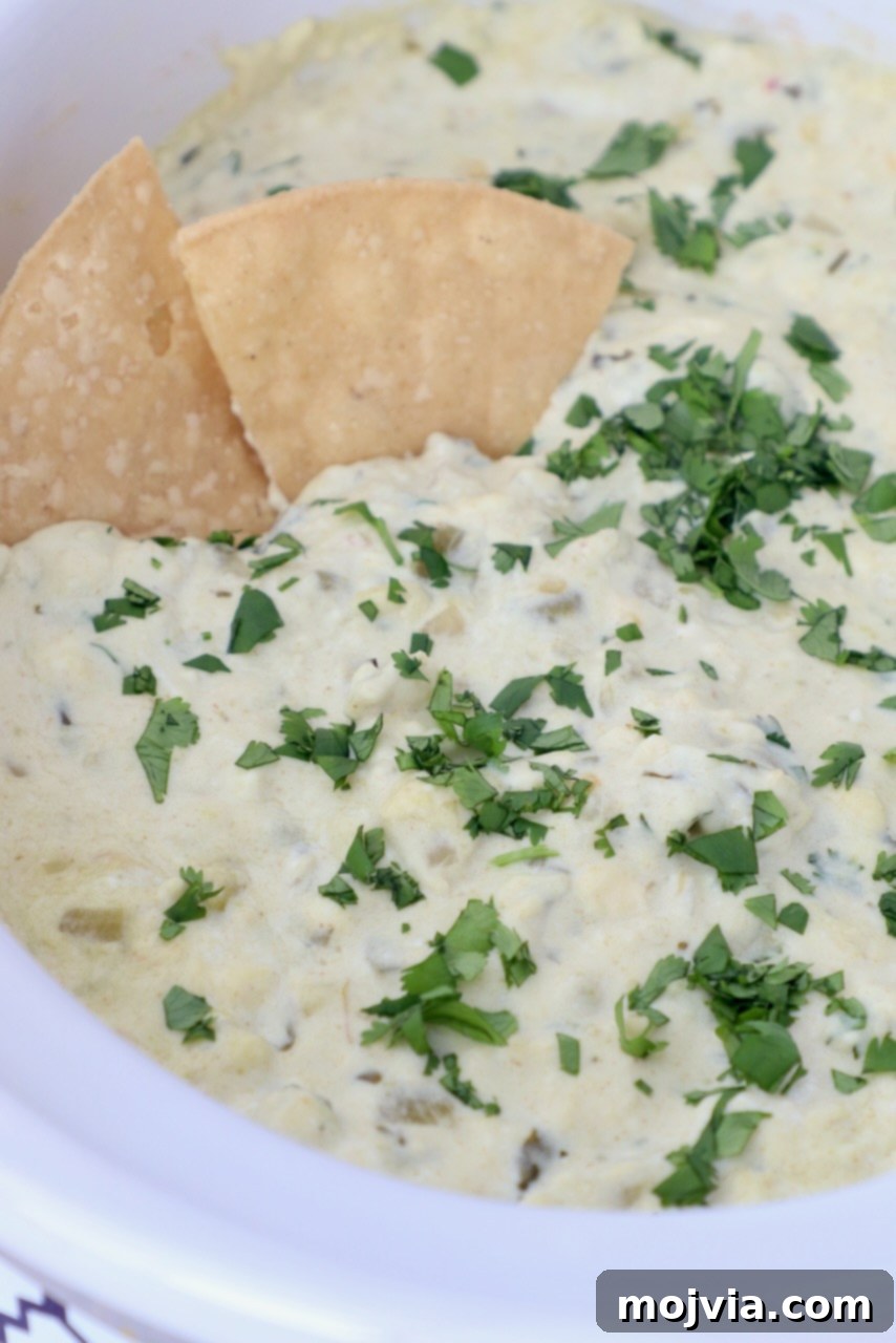 Set It and Forget It Green Chile Queso Blanco 2 Creamy slow cooker queso blanco dip served with tortilla chips, garnished with fresh cilantro.
