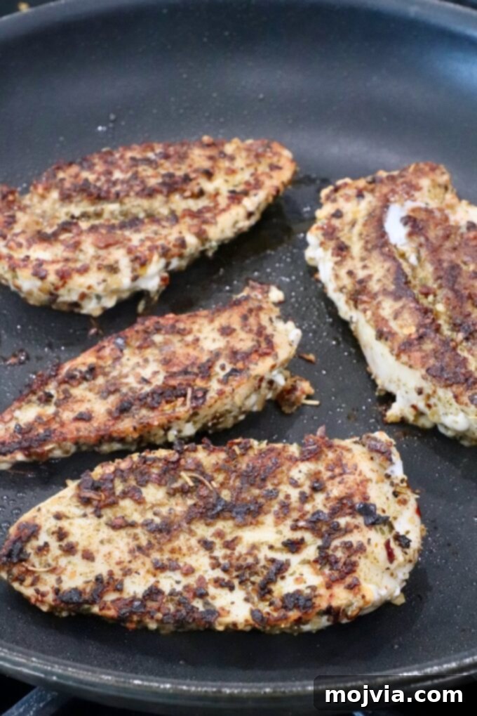 seared seasoned chicken breasts in a skillet