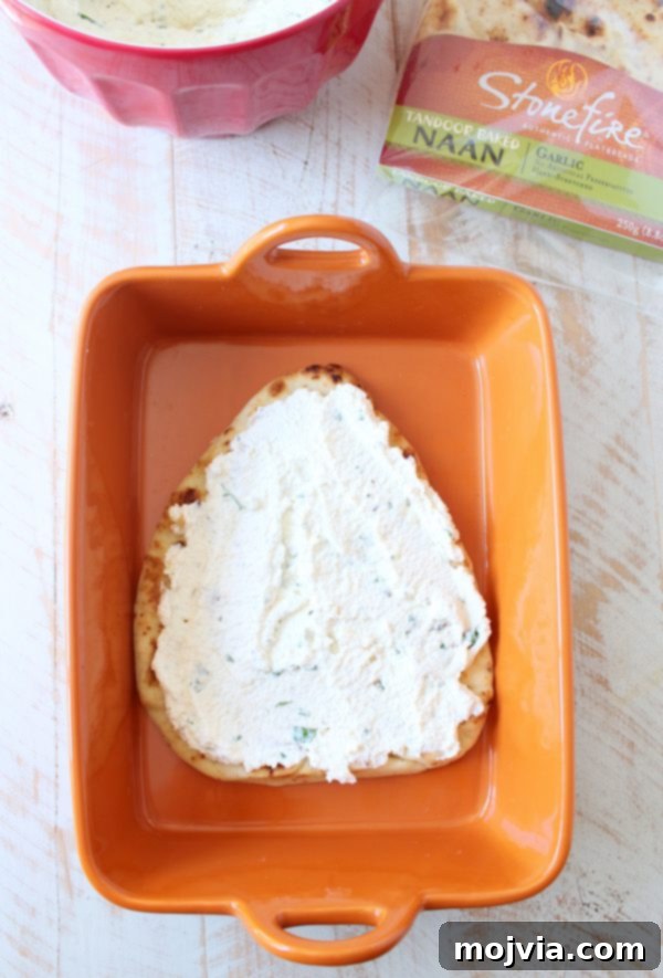 Layering the rich herbed ricotta cheese mixture onto the garlic naan base