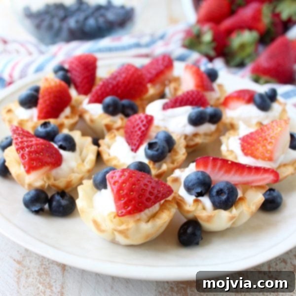 Close-up of Berry Cream Fillo Baskets with red and blue berries, ideal for summer gatherings and holiday desserts.