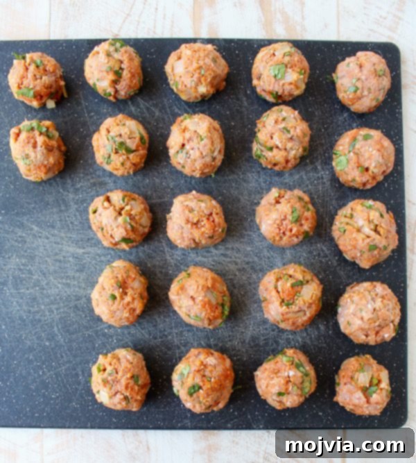 Thai Peanut Turkey Meatball Bliss 5 Uncooked turkey meatballs neatly arranged on a cutting board