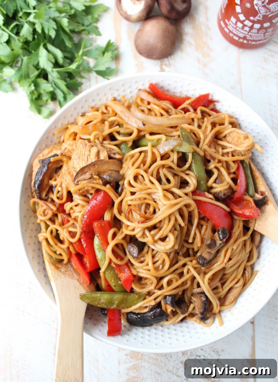 Homemade Chicken Lo Mein in Minutes 2 prepared chicken lo mein with vegetables in a bowl with serving spoons