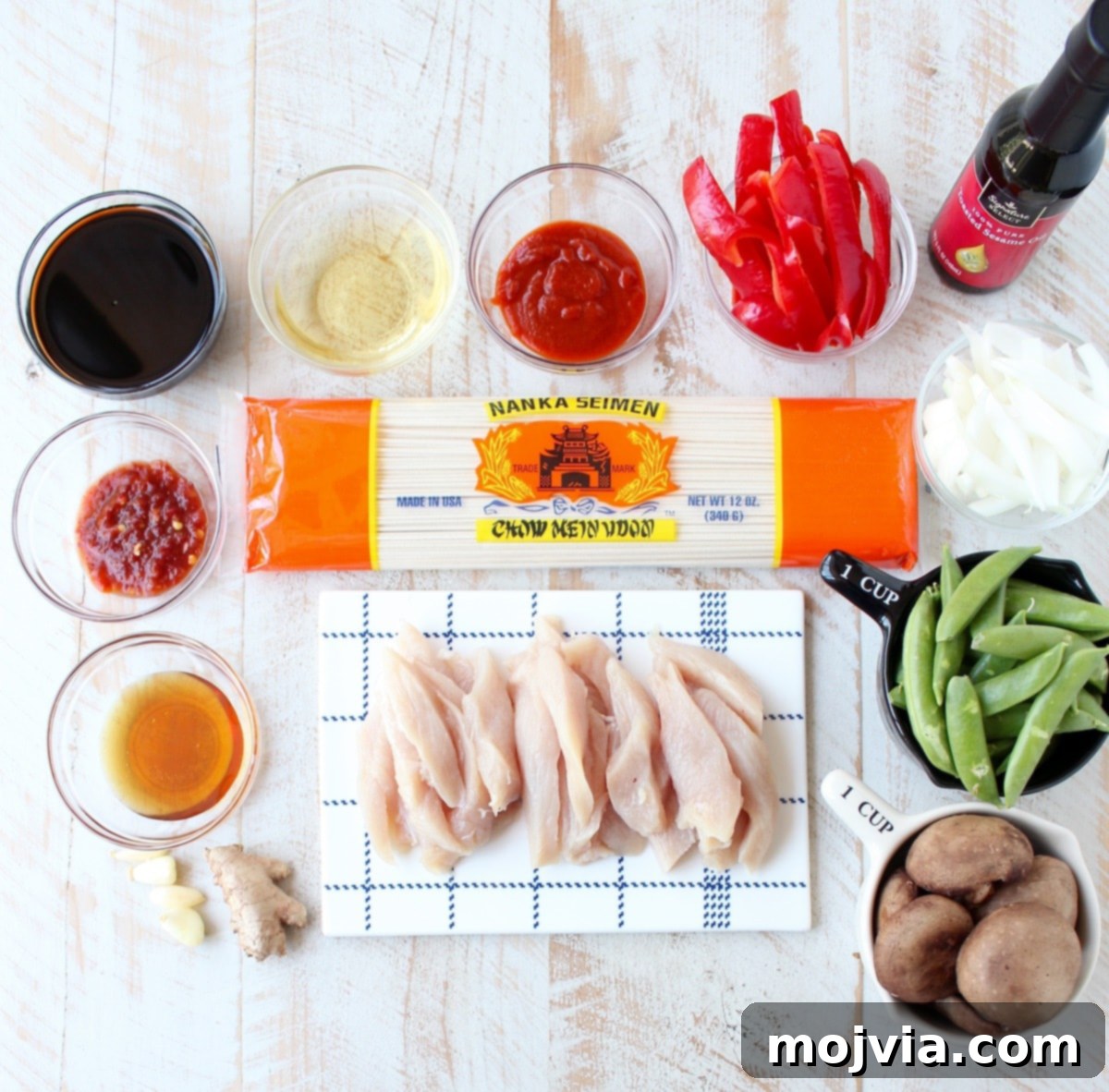 Homemade Chicken Lo Mein in Minutes 3 ingredients for chicken lo mein on a white wood board