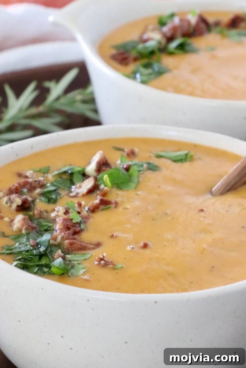 Spiced Sweet Potato Warmth 5 Two bowls of sweet potato soup, garnished with chopped fresh parsley and nuts, ready to be served.