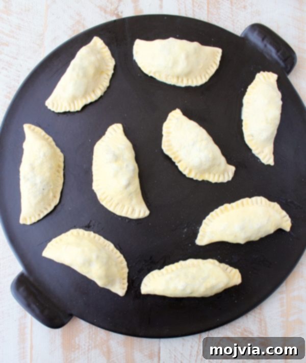 Fiery Jamaican Jerk Beef Patties 9 An array of raw Jamaican Jerk Beef Patties, sealed and brushed with egg wash, ready to be baked.