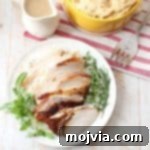A serving of Roasted Cajun Mashed Potatoes with sliced Cajun Turkey and gravy.