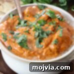 cooked butter chicken in bowl with spoon