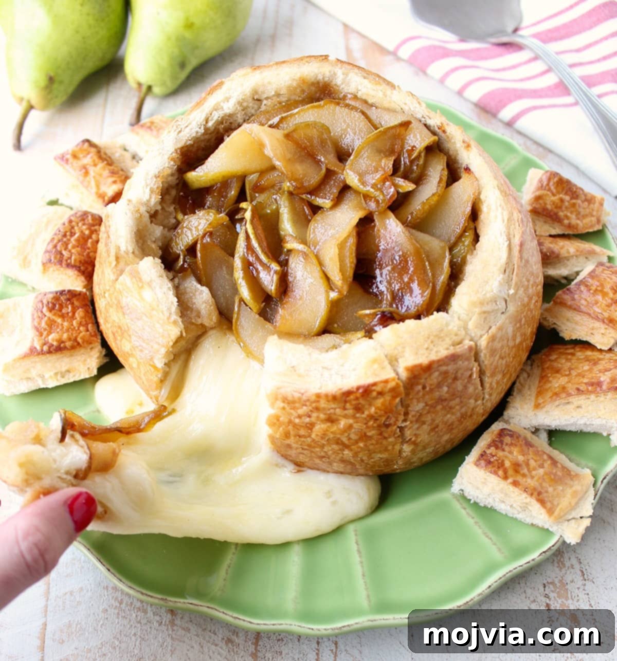 Decadent Caramelized Pear and Brie Bread Bowl 4 A glorious pull of creamy brie cheese from a sourdough bread bowl, richly layered with caramelized pears and ready to be enjoyed.