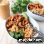 Roasted sweet potatoes and quinoa are topped with delicious Thai peanut sauce in this healthy, gluten free & vegan buddha bowl recipe!