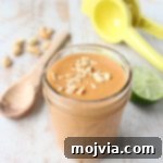 Creamy Thai Peanut Sauce 2 Creamy Thai Peanut Sauce in a white bowl, garnished with peanuts and cilantro
