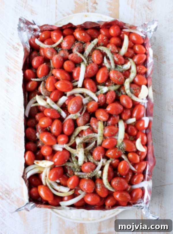 Fire-Kissed Tomato Bisque 4 cherry tomatoes, onions and garlic on a foil lined baking sheet