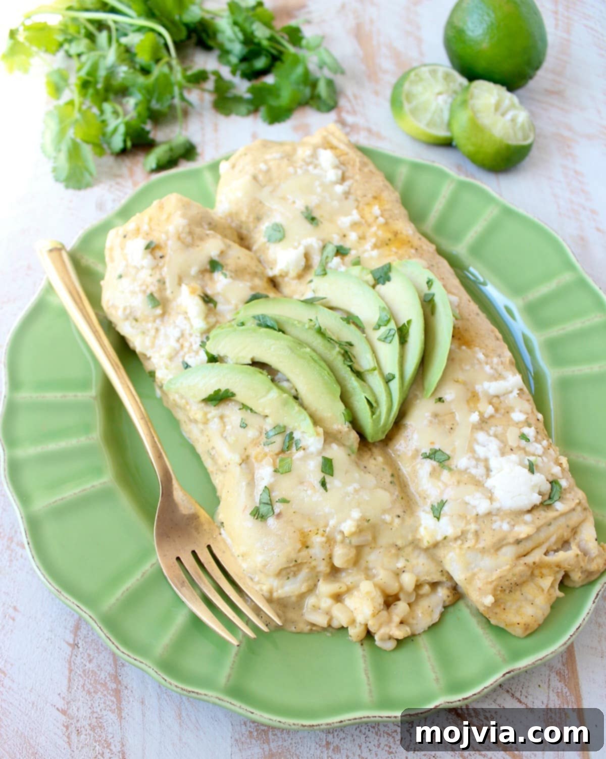 The best vegetarian enchiladas ever combine two cheeses, corn & deliciously creamy avocado sauce for a mouth watering meatless Mexican recipe!