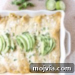 The best vegetarian enchiladas ever combine two cheeses, corn & deliciously creamy avocado sauce for a mouth watering meatless Mexican recipe!