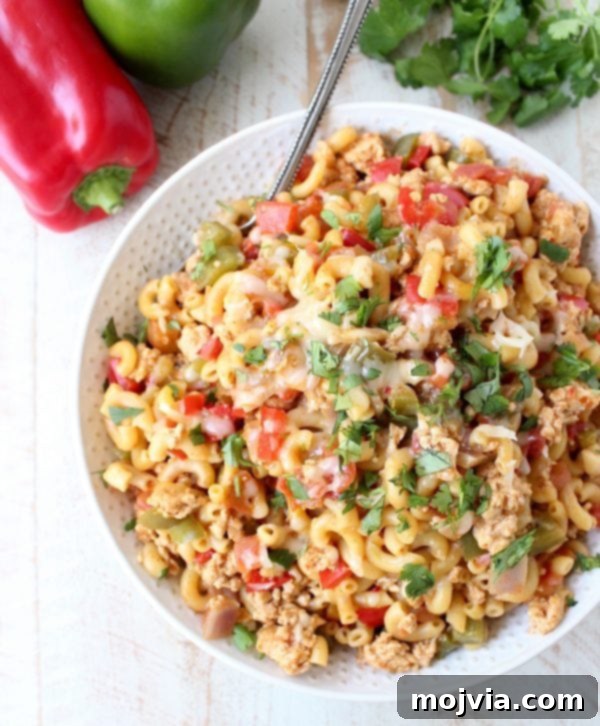 Close-up of creamy One Pot Chicken Fajita Pasta with melted cheese and fresh herbs