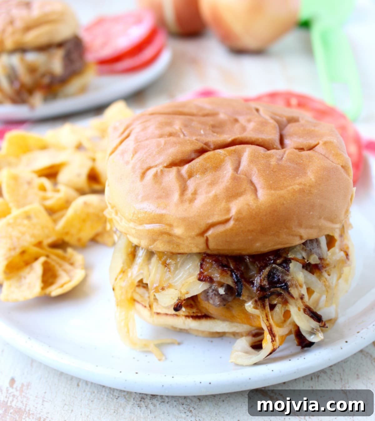 Oklahoma Onion Smash Burger 13 Close-up of a fully assembled Oklahoma Fried Onion Burger, served with side dishes, showcasing its delicious layers and golden-brown bun.