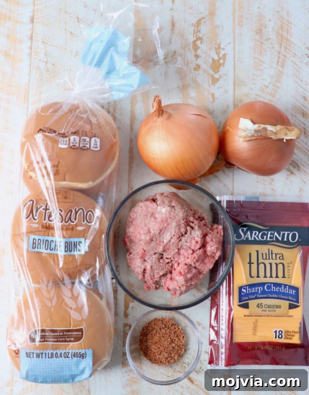 Oklahoma Onion Smash Burger 3 Collection of fresh ingredients for preparing fried onion burgers laid out on a white wooden board
