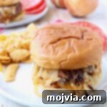 Oklahoma Onion Smash Burger 15 onion fried burger on plate with chips and sliced tomatoes