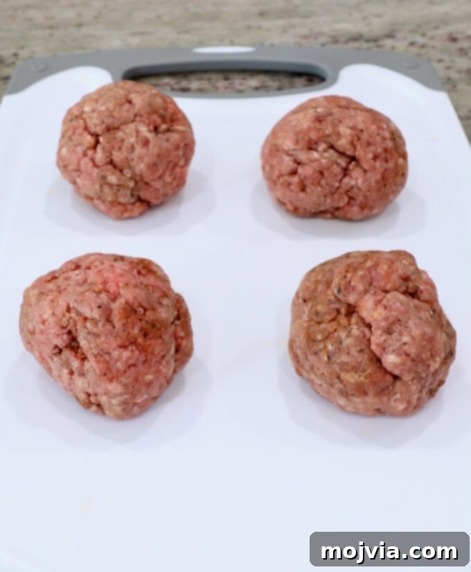 Oklahoma Onion Smash Burger 5 Neatly formed balls of ground beef resting on a cutting board, prepared for smashing onto the griddle.