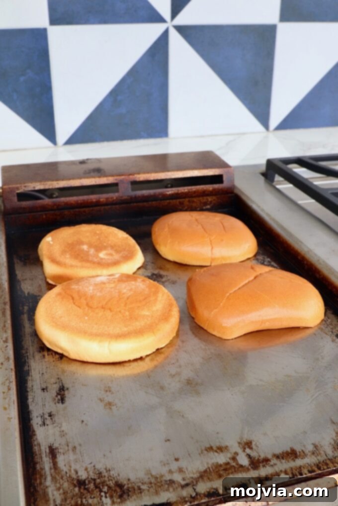 Oklahoma Onion Smash Burger 6 Hamburger buns toasting face-down on a hot griddle, achieving a perfect golden crisp.