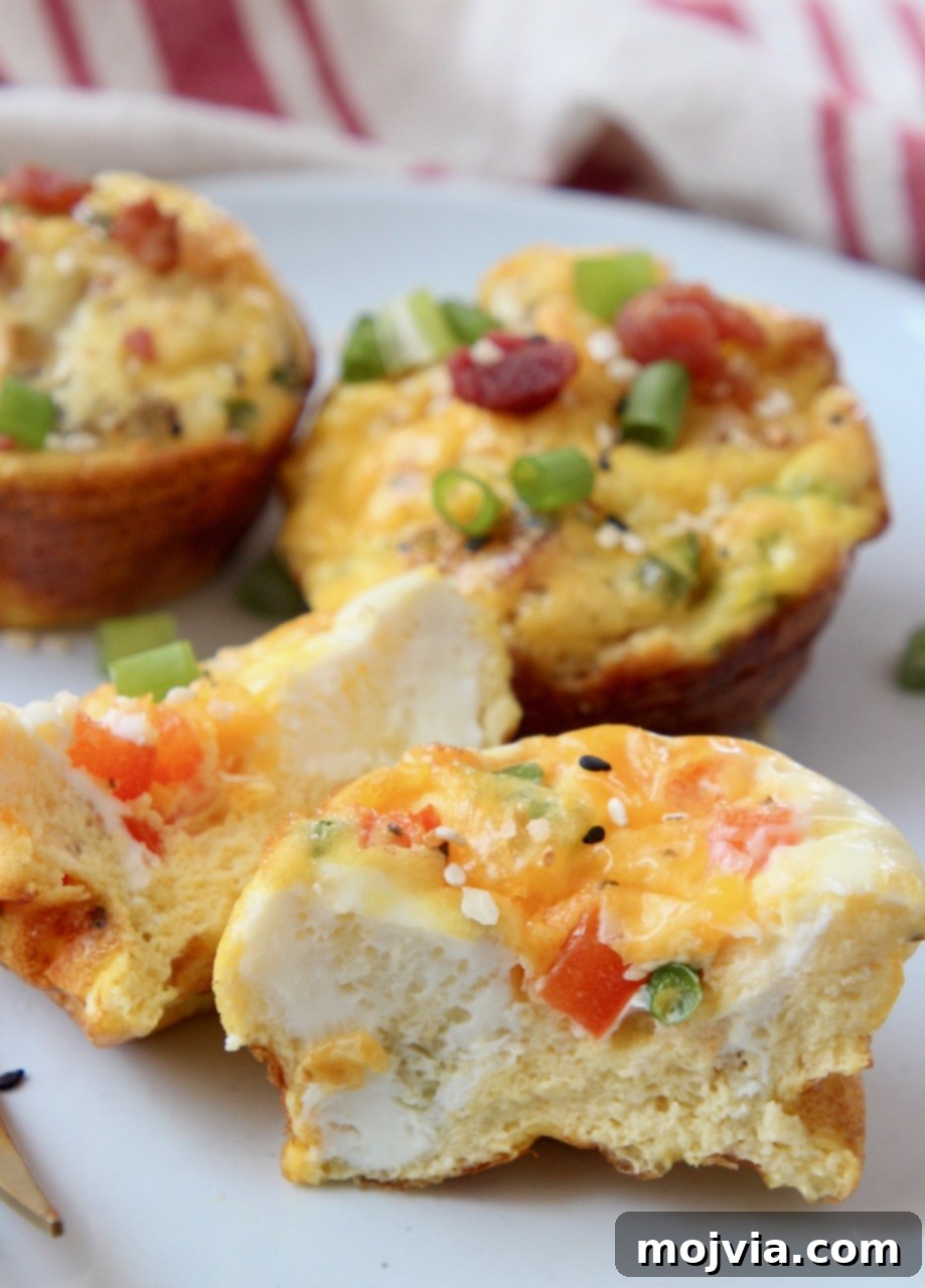 A healthy breakfast egg muffin, cut in half to show its delicious fillings, served on a white plate