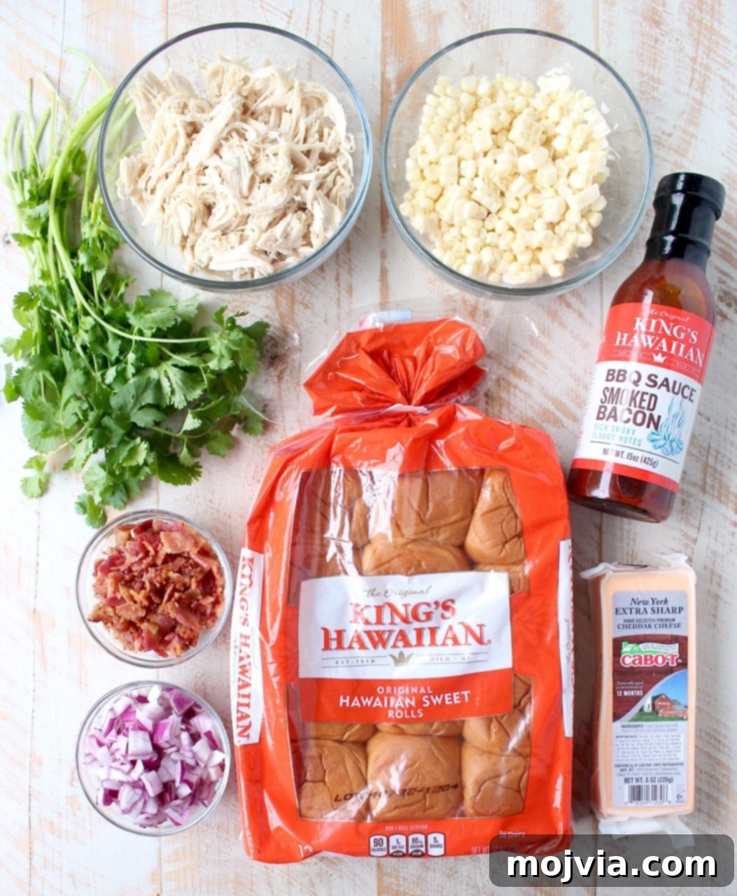 Sweet & Smoky BBQ Chicken Salad Sliders 3 Close-up of a hand reaching for a BBQ Chicken Salad Slider, showcasing the vibrant ingredients and soft Hawaiian roll.