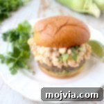 Mexican turkey burgers are covered in cotija cheese, guacamole and grilled Mexican street corn for a flavorful summer burger recipe!