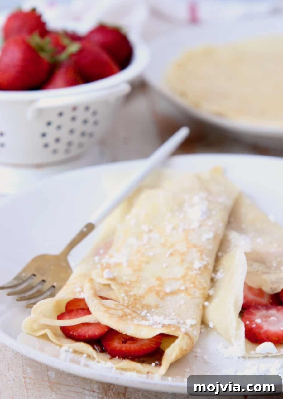 Authentic French Crepes Made Easy 6 Nutella strawberry filled crepes on plate with fork