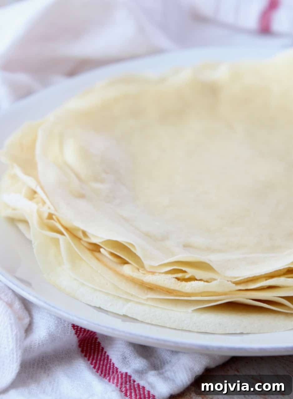 Authentic French Crepes Made Easy 7 crepes stacked on top of each other on a plate