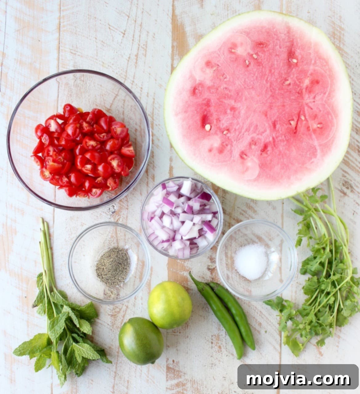 Sweet Heat Watermelon Salsa 3 Fresh ingredients for watermelon salsa laid out on a white wooden board