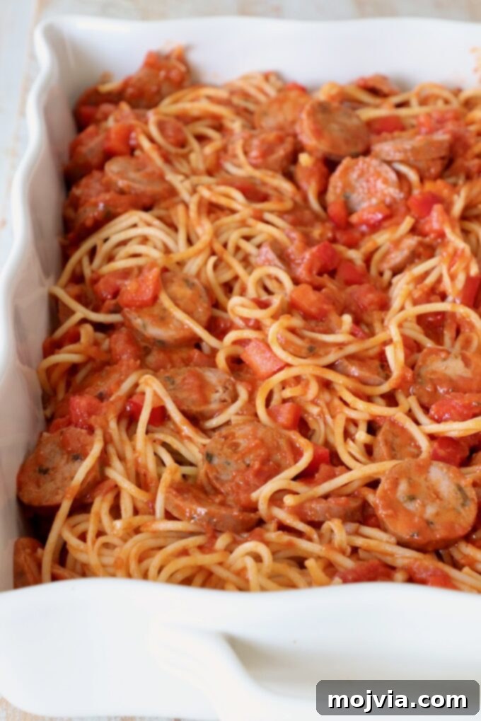 Ultimate Pizza Spaghetti Casserole 5 The spaghetti, marinara, sausage, and pepper mixture transferred into a 9x13 inch casserole dish, ready for baking.