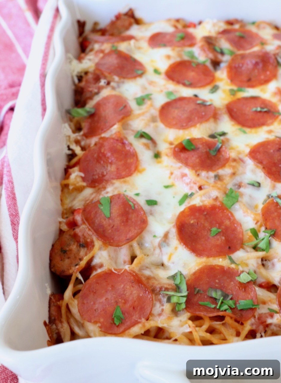 Ultimate Pizza Spaghetti Casserole 8 A beautifully baked pizza baked spaghetti casserole in its dish, showing melted cheese and crispy pepperonis.