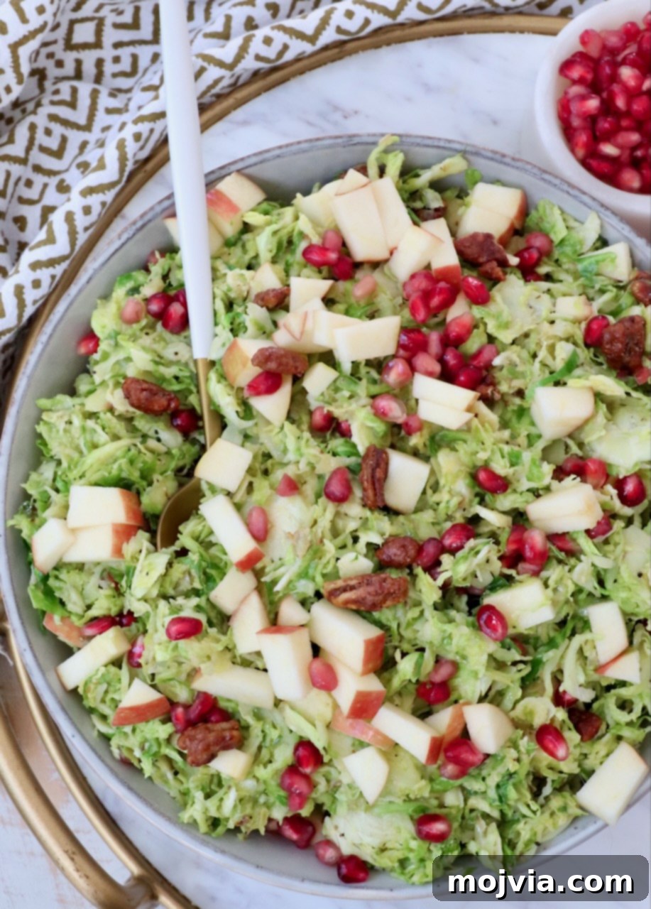 Another close-up shot of the finished shaved Brussels sprout salad, highlighting the glistening dressing and diverse ingredients.