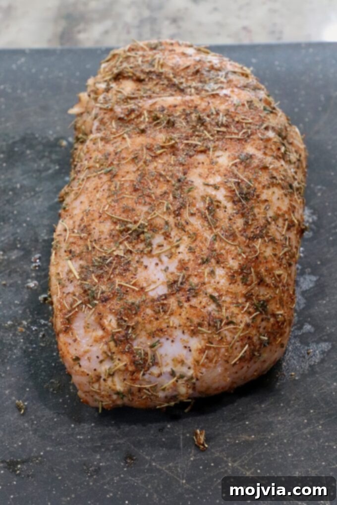 Melt-in-Your-Mouth Slow Cooker Turkey 4 Turkey breast rubbed with seasoning and olive oil on a cutting board, ready for the slow cooker.