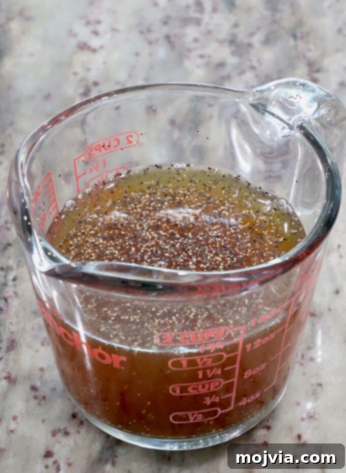 Melt-in-Your-Mouth Slow Cooker Turkey 5 A glass measuring cup containing apple cider, maple syrup, salt, and pepper, whisked together for the glaze.