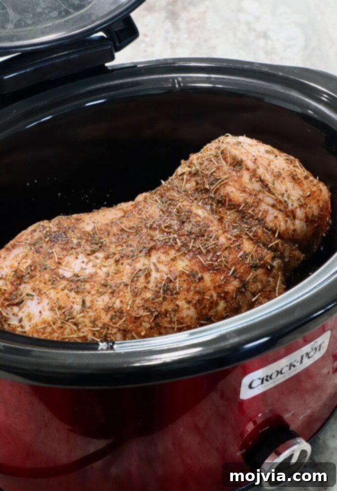 Melt-in-Your-Mouth Slow Cooker Turkey 7 Seasoned turkey breast placed gently on top of the onion halves in the slow cooker, with the glaze liquid poured in.